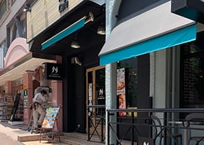 一つ目の信号を超えたところにあるNEW YORKER’S Cafeの入っているビルの隣のビル「サンフラワービル3F」になります